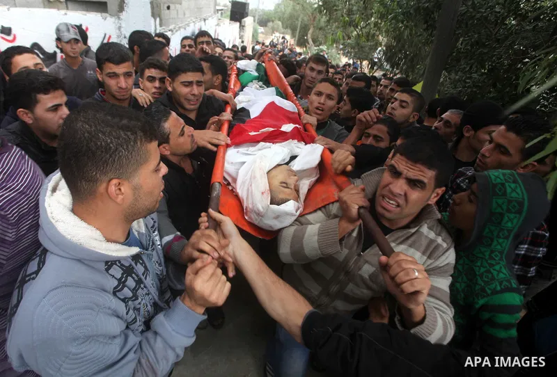 Mourners carry the body of killed Palestinian civilian Ahmad Dardasawy, 18, during his funeral in Gaza City on November 11, 2012 , the day after he was killed in Israeli shelling as clashes erupted along the Isreali-Gaza...
