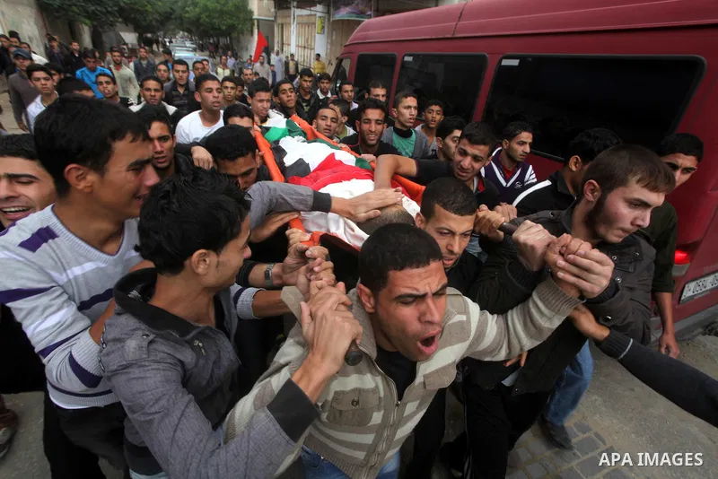 Mourners carry the body of killed Palestinian civilian Ahmad Dardasawy, 18, during his funeral in Gaza City on November 11, 2012 , the day after he was killed in Israeli shelling as clashes erupted along the Isreali-Gaza...