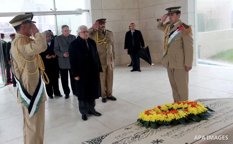 Palestinian President Mahmoud Abbas (C) gives respect after he lays a wreath over late leader Yasser Arafat grave prior the official ceremony of marking Arafat's 8th Anniversary of his death, in the West Bank city of Ram...