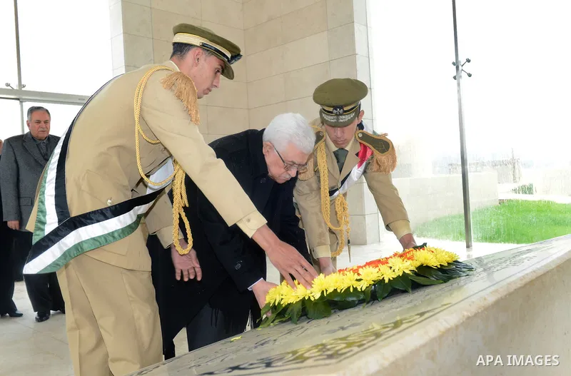 Palestinian President Mahmoud Abbas (C) gives respect after he lays a wreath over late leader Yasser Arafat grave prior the official ceremony of marking Arafat's 8th Anniversary of his death, in the West Bank city of Ram...