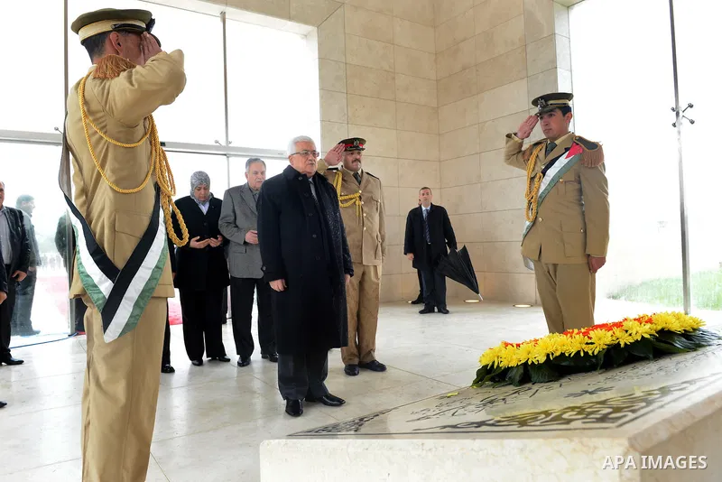 Palestinian President Mahmoud Abbas (C) gives respect after he lays a wreath over late leader Yasser Arafat grave prior the official ceremony of marking Arafat's 8th Anniversary of his death, in the West Bank city of Ram...