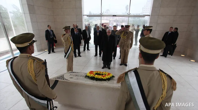 Palestinian President Mahmoud Abbas (L) makes his way to late leader Yasser Arafat grave prior the official ceremony of marking Arafat's 8th Anniversary of his death, in the West Bank city of Ramallah on Nov. 11, 2012. P...