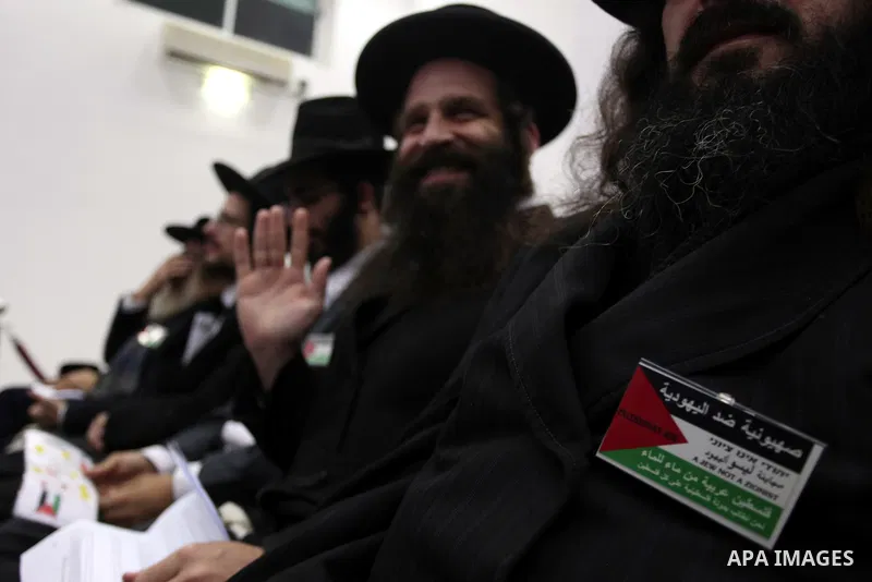 Orthodox Jews listen to Palestinian President Mahmud Abbas delivering a speech to mark the eighth anniversary of the death of the late leader Yasser Arafat, in the West Bank city of Ramallah on November 11, 2012. Palesti...