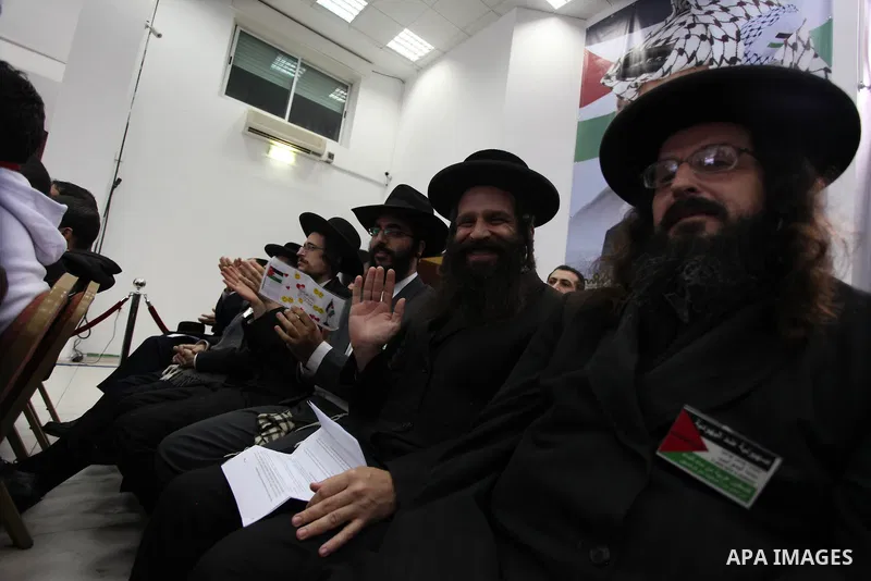 Orthodox Jews listen to Palestinian President Mahmud Abbas delivering a speech to mark the eighth anniversary of the death of the late leader Yasser Arafat, in the West Bank city of Ramallah on November 11, 2012. Palesti...