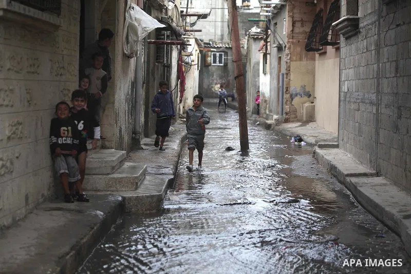 A Palestinian boy walks at a flooded street in al-Shatee refugee camp in Gaza City on November 11, 2012. In the aftermath of the Israeli military Operation Cast Lead in 2008/2009, Palestinian refugees in Gaza camps need...