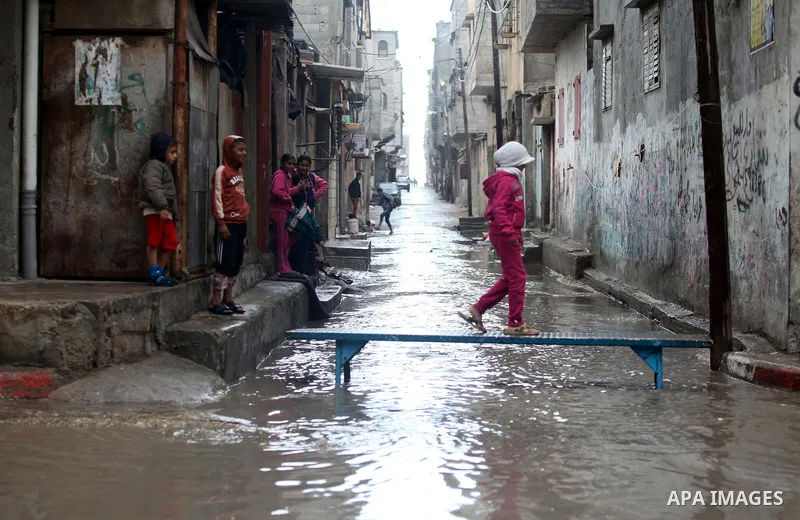 A Palestinian girl crosses a flooded street in al-Shatee refugee camp in Gaza City on November 11, 2012. In the aftermath of the Israeli military Operation Cast Lead in 2008/2009, Palestinian refugees in Gaza camps need...