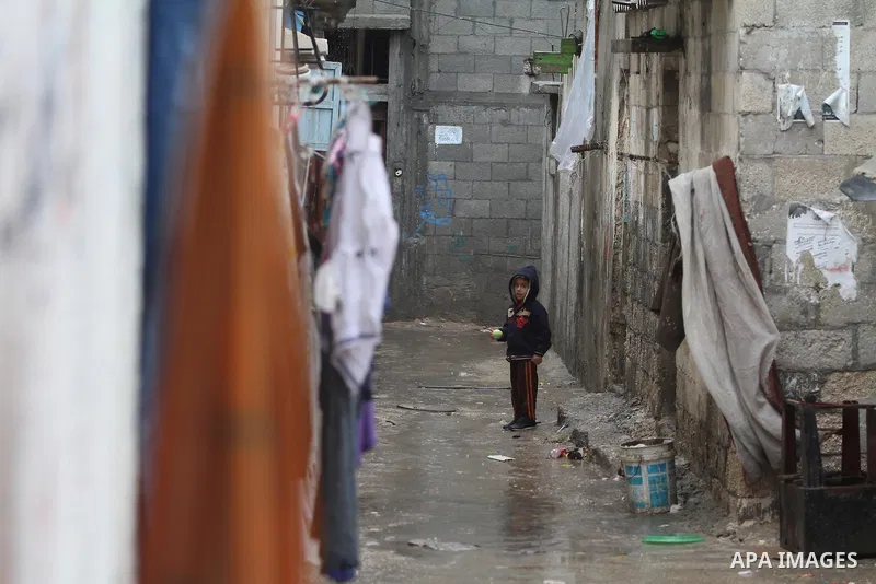 A Palestinian child stands in front of his house at a flooded street in al-Shatee refugee camp in Gaza City on November 11, 2012. In the aftermath of the Israeli military Operation Cast Lead in 2008/2009, Palestinian ref...