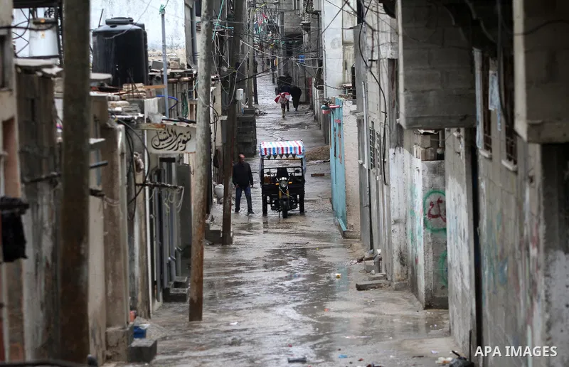 Palestinians walk at a flooded street in al-Shatee refugee camp in Gaza City on November 11, 2012. In the aftermath of the Israeli military Operation Cast Lead in 2008/2009, Palestinian refugees in Gaza camps need more s...