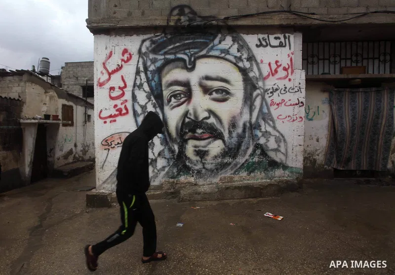 A Palestinian man walks past a mural of the late Palestinian leader Yasser Arafat in al-Shatee refugee camp in Gaza City on November 11, 2012. Palestinians are coordinating with Russia, as well as Swiss and French expert...