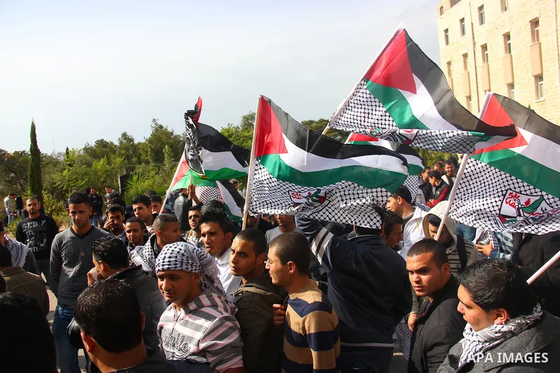Palestinians hold-up national flags and posters of the late Palestinian leader Yasser Arafat mark the eighth anniversary of his death, in the West Bank city of Hebron on November 11, 2012. Palestinians are coordinating w...