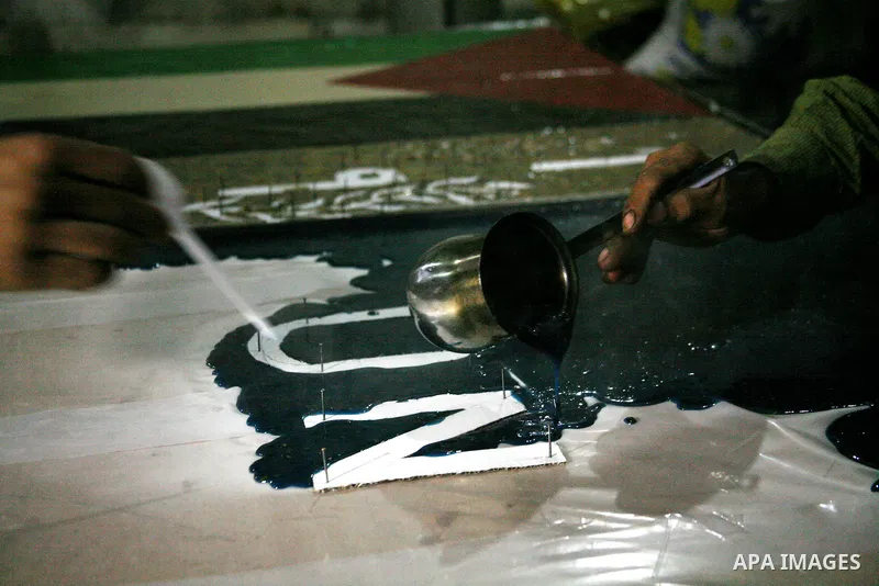 Farmer Suhail Brighit paints a Palestinian flag with the United Nations "UN" flag in support Palestinian President Mahmoud Abbas's step to seek non-member observer status for Palestine at the United Nations, in the West...