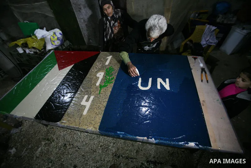 Farmer Suhail Brighit paints a Palestinian flag with the United Nations "UN" flag in support Palestinian President Mahmoud Abbas's step to seek non-member observer status for Palestine at the United Nations, in the West...