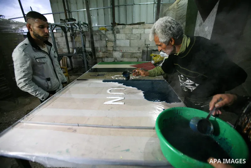 Farmer Suhail Brighit paints a Palestinian flag with the United Nations "UN" flag in support Palestinian President Mahmoud Abbas's step to seek non-member observer status for Palestine at the United Nations, in the West...