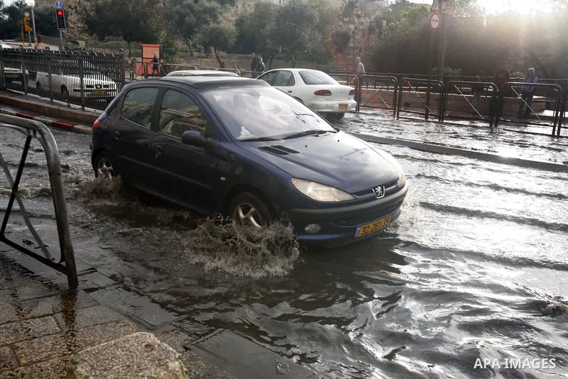 Cars cross a flooded street outside al-Aqsa Mosque compound, Islam's third holiest, in the old city of Jerusalem on November 12, 2012. Photo by Mahfouz Abu Turk
