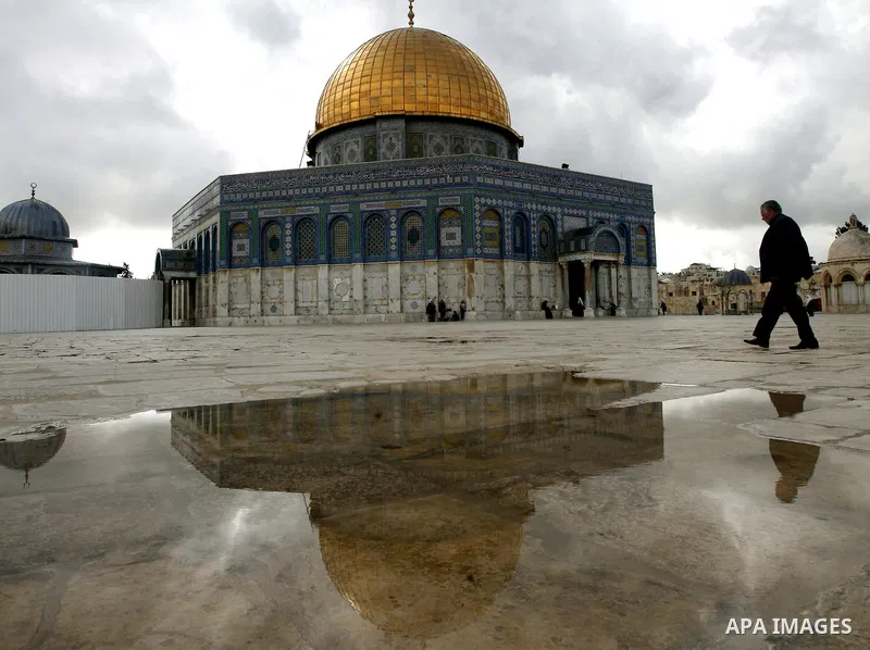 Palestinians walk in front of the Dome of the Rock mosque at Al-Aqsa mosque compound, Islam's third holiest, in the old city of Jerusalem on November 12, 2012. Photo by Mahfouz Abu Turk