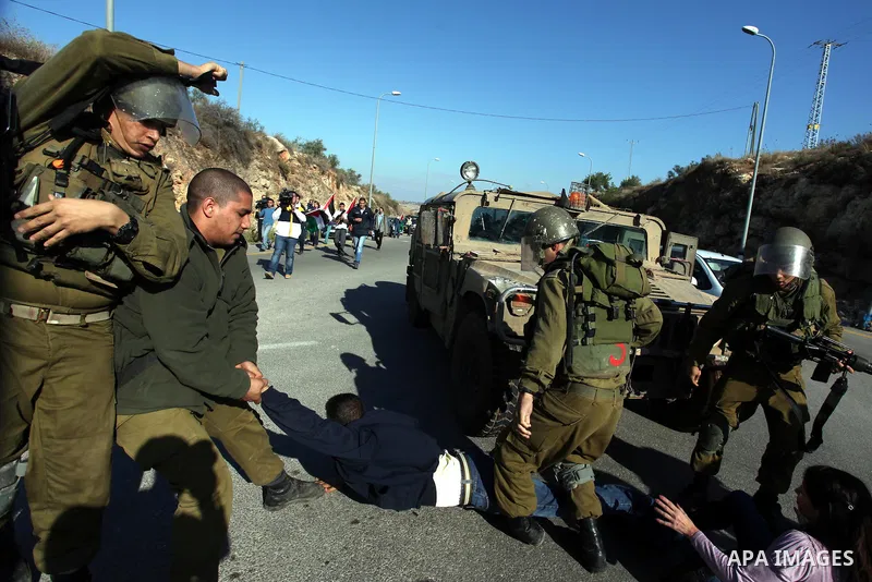 Israeli soldiers scuffle with a demonstrator as Palestinian and foreign activists take part in a demonstration in support of the Palestinian statehood petition at the U.N. General Assembly, near the West Bank city of Ram...