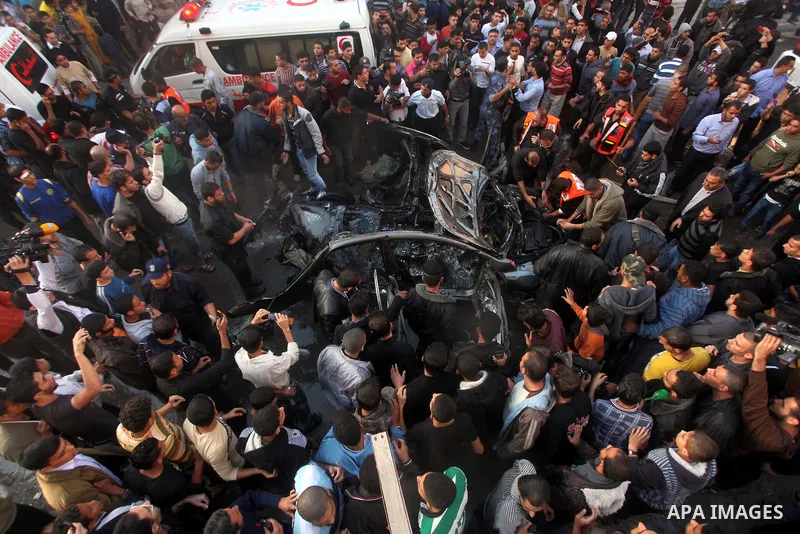 Palestinian firefighters extinguish fire from the car of Ahmad Jaabari, head of the military wing of the Hamas movement, the Ezzedin Qassam Brigades, after it was hit by an Israeli air strike in Gaza City on November 14,...
