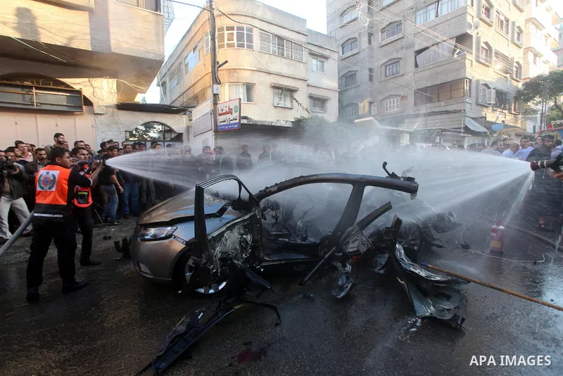 Palestinian firefighters extinguish fire from the car of Ahmad Jaabari, head of the military wing of the Hamas movement, the Ezzedin Qassam Brigades, after it was hit by an Israeli air strike in Gaza City on November 14,...
