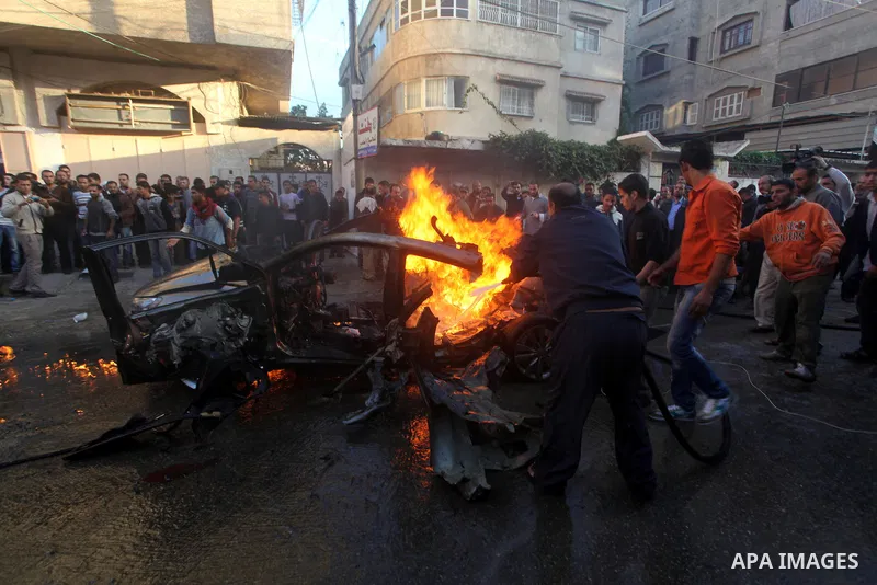 Palestinian firefighters extinguish fire from the car of Ahmad Jaabari, head of the military wing of the Hamas movement, the Ezzedin Qassam Brigades, after it was hit by an Israeli air strike in Gaza City on November 14,...