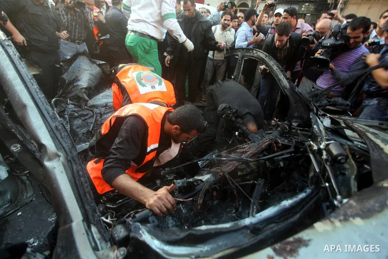 Palestinian firefighters extinguish fire from the car of Ahmad Jaabari, head of the military wing of the Hamas movement, the Ezzedin Qassam Brigades, after it was hit by an Israeli air strike in Gaza City on November 14,...