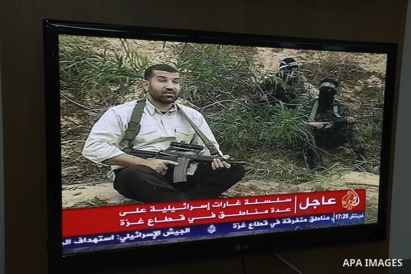 Palestinians watch T.V news of al-Jazeera at their work in Gaza city November 14, 2012. Israel killed the military commander of the Islamist group Hamas in a missile strike on the Gaza Strip on Wednesday and launched air...