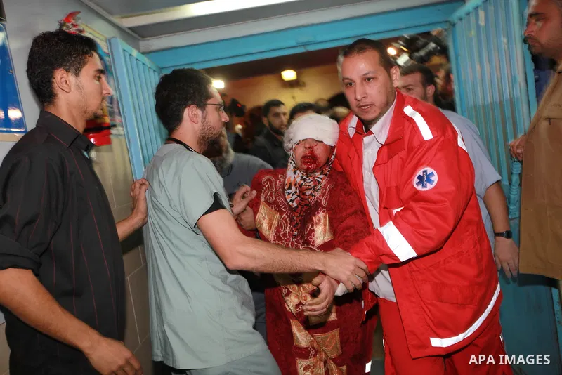 Medics men carry a wounded Palestinian woman into the treatment room of Shifa hospital following an Israeli airstrike in Gaza City, Wednesday, Nov. 14, 2012. The Israeli military said its assassination of the Hamas milit...
