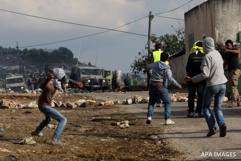Palestinian protesters throw stones towards Israeli troops during clashes in the village of Kafr Qaddum near the West Bank city of Nablus on November 14, 2012. Palestinians held rallies across the West Bank, a day before...