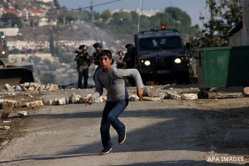 A Palestinian protestor runs away from Israeli soldiers during clashes in the village of Kafr Qaddum, near the West Bank city of Nablus, on November 14, 2012. Palestinians held rallies across the West Bank, a day before...