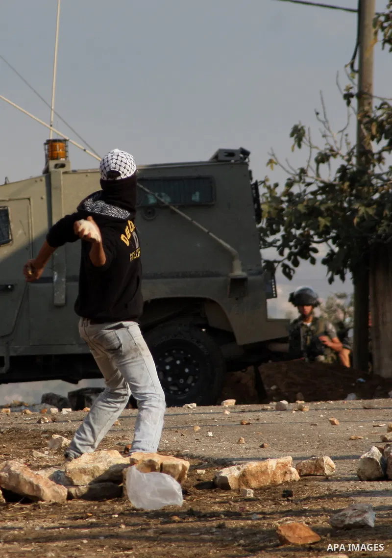 A Palestinian protester throws a stone towards Israeli troops during clashes in the village of Kafr Qaddum near the West Bank city of Nablus on November 14, 2012. Palestinians held rallies across the West Bank, a day bef...