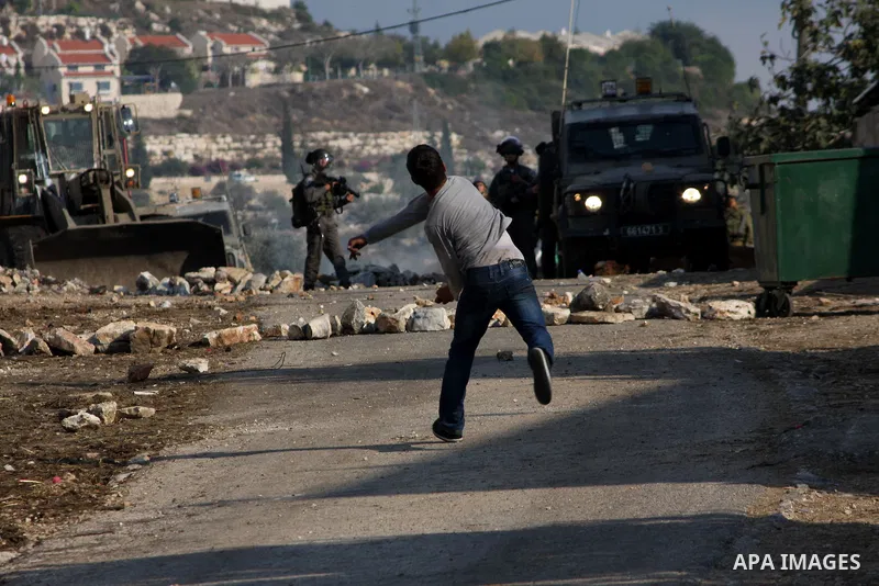 A Palestinian protester throws a stone towards Israeli troops during clashes in the village of Kafr Qaddum near the West Bank city of Nablus on November 14, 2012. Palestinians held rallies across the West Bank, a day bef...