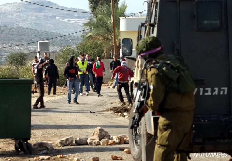 Palestinian protesters throw stones towards Israeli troops during clashes in the village of Kafr Qaddum near the West Bank city of Nablus on November 14, 2012. Palestinians held rallies across the West Bank, a day before...