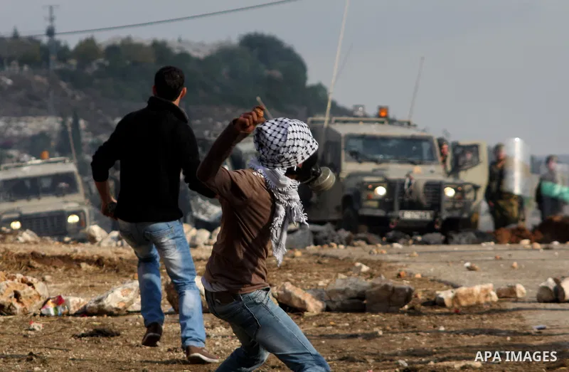 Palestinian protesters throw stones towards Israeli troops during clashes in the village of Kafr Qaddum near the West Bank city of Nablus on November 14, 2012. Palestinians held rallies across the West Bank, a day before...