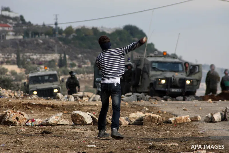 A Palestinian protester throws a stone towards Israeli troops during clashes in the village of Kafr Qaddum near the West Bank city of Nablus on November 14, 2012. Palestinians held rallies across the West Bank, a day bef...