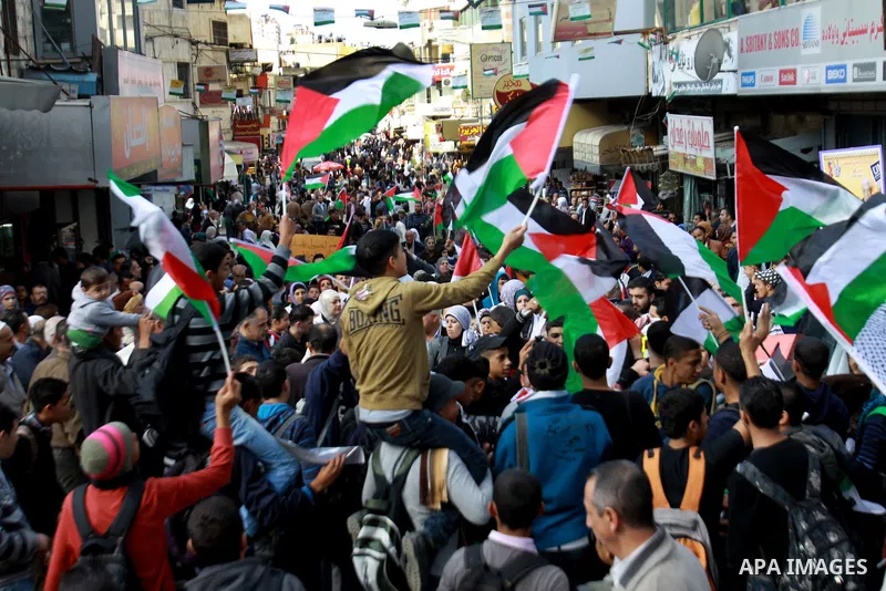 Palestinians hold national flags and pictures of leader Yasser Arafat during a protest to mark the 24th anniversary Palestinian Independence Day, in the West Bank city of Nablus on November 14, 2012. Celebrations were he...