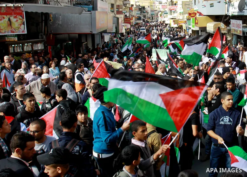 Palestinians hold national flags and pictures of leader Yasser Arafat during a protest to mark the 24th anniversary Palestinian Independence Day, in the West Bank city of Nablus on November 14, 2012. Celebrations were he...