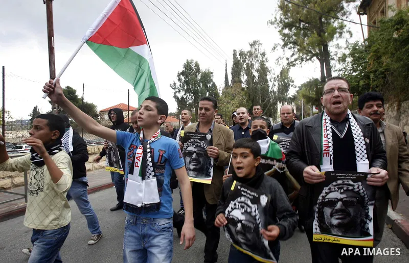 Palestinian protesters hold pictures of late Palestinian leader Yasser Arafat during a demonstration in support of the Palestinian statehood petition at the U.N. General Assembly near the Damascus gate in Jerusalem's Old...