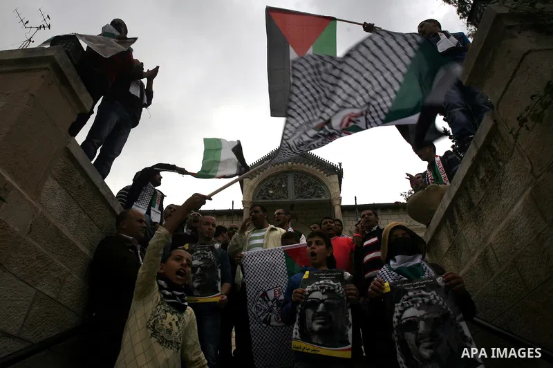 Palestinian protesters hold pictures of late Palestinian leader Yasser Arafat during a demonstration in support of the Palestinian statehood petition at the U.N. General Assembly near the Damascus gate in Jerusalem's Old...