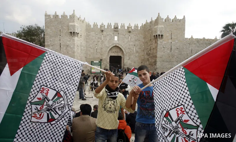 Palestinian protesters hold pictures of late Palestinian leader Yasser Arafat during a demonstration in support of the Palestinian statehood petition at the U.N. General Assembly near the Damascus gate in Jerusalem's Old...