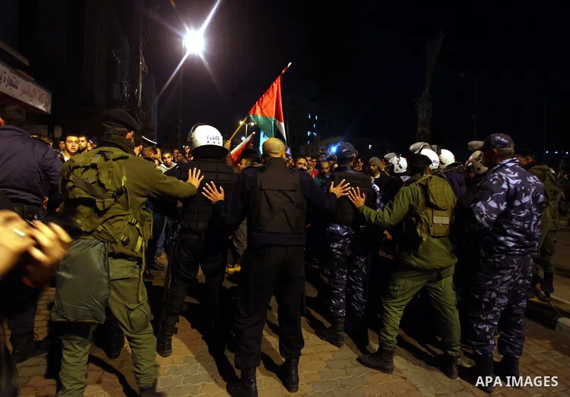 Palestinian police officers stand guard as protesters march in the West Bank city of Ramallah on November 14, 2012 during a demonstration in support of the people of the Gaza Strip and against Israeli air strikes. Severa...