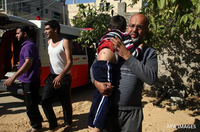 A Palestinian man carries his wounded son to the hospital after an Israeli air strike in Khan Younis in the southern Gaza Strip November 15, 2012. Hamas fired dozens of rockets into southern Israel on Thursday, killing t...