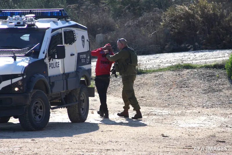 Israeli soldiers detain Palestinian youths in a protest to block a road leading to Huwwara checkpoint near the West Bank city of Nablus during a demonstration in support of the people of the Gaza Strip and against Israel...