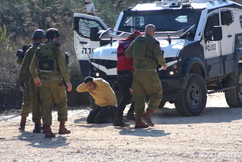 Israeli soldiers detain Palestinian youths in a protest to block a road leading to Huwwara checkpoint near the West Bank city of Nablus during a demonstration in support of the people of the Gaza Strip and against Israel...
