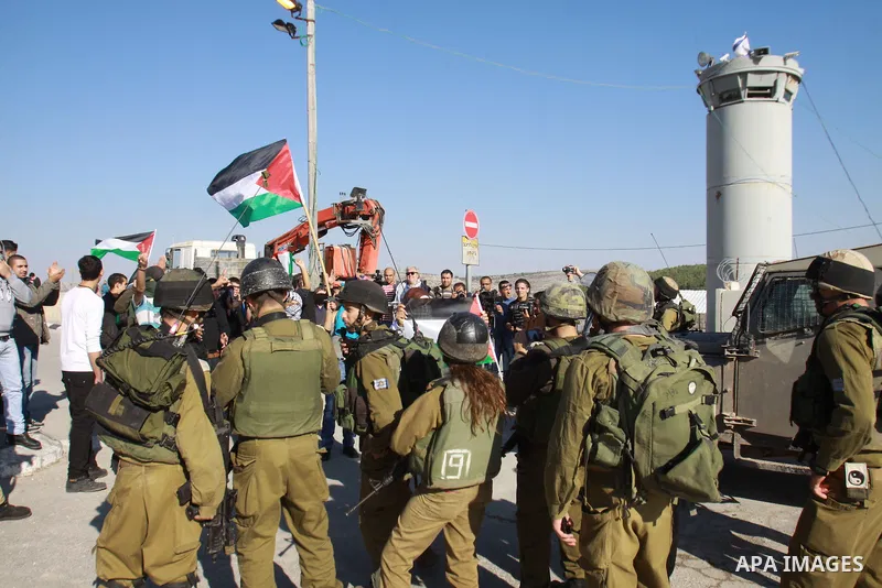 Palestinian activists scuffle with Israeli soldiers while they block a road leading to Huwwara checkpoint near the West Bank city of Nablus during a demonstration in support of the people of the Gaza Strip and against Is...