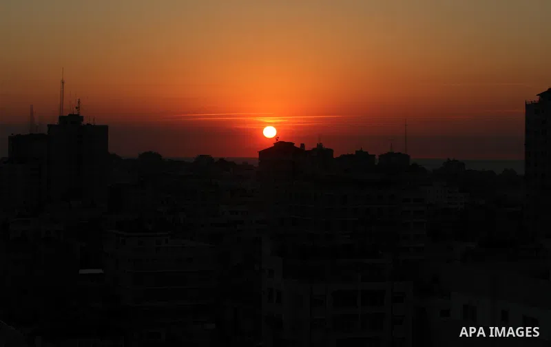 An Image shows the sunset between buildings in the western of Gaza City, Thursday, Nov. 15, 2012. Israel barraged the Gaza Strip with airstrikes and shelling Wednesday and killed the Hamas military chief in a targeted st...