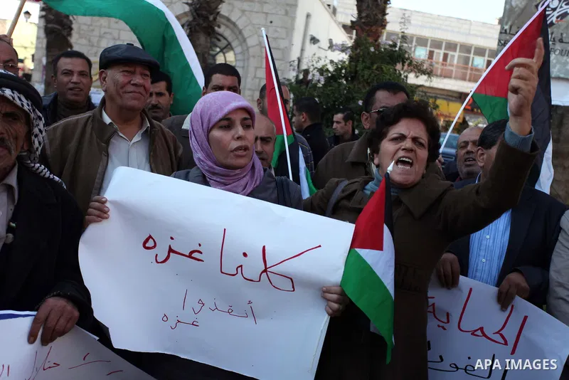 Palestinian activists hold their national flags during a protest against the Israeli military operations in Gaza strip, in the West Bank city of Ramallah on November 15, 2012. Several Palestinians were killed following a...