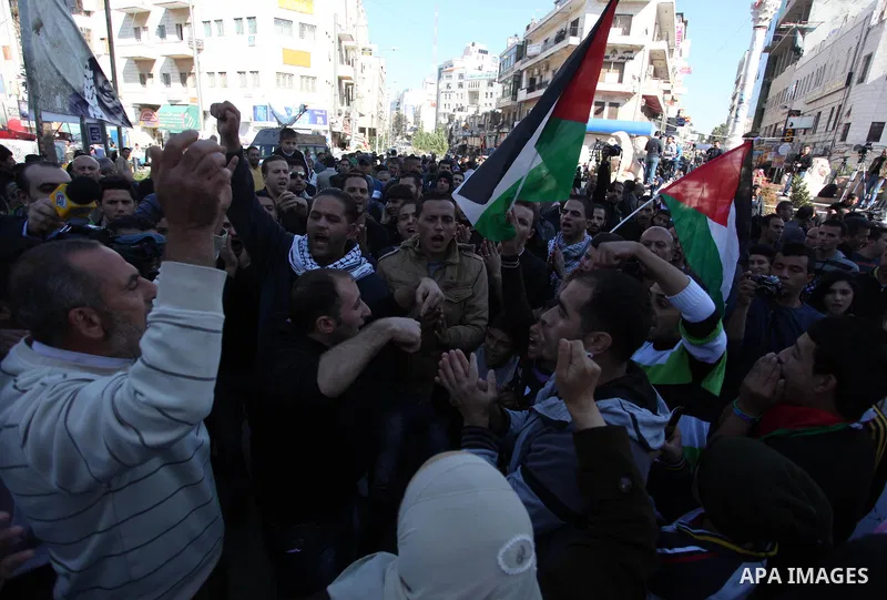 Palestinian activists hold their national flags during a protest against the Israeli military operations in Gaza strip, in the West Bank city of Ramallah on November 15, 2012. Several Palestinians were killed following a...