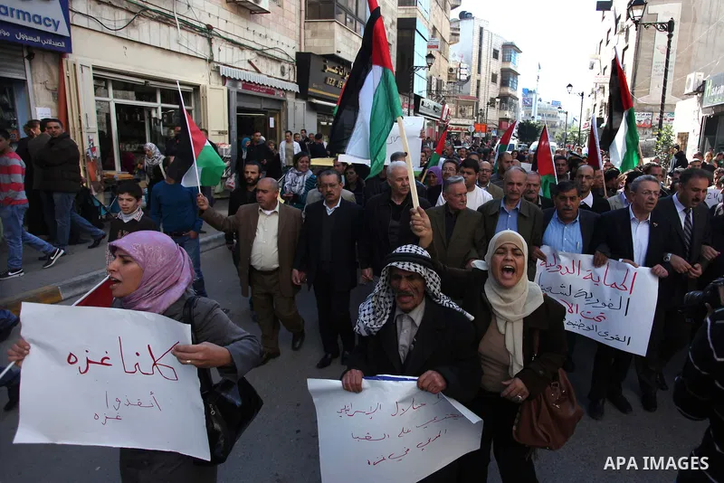 Palestinian activists hold their national flags during a protest against the Israeli military operations in Gaza strip, in the West Bank city of Ramallah on November 15, 2012. Several Palestinians were killed following a...