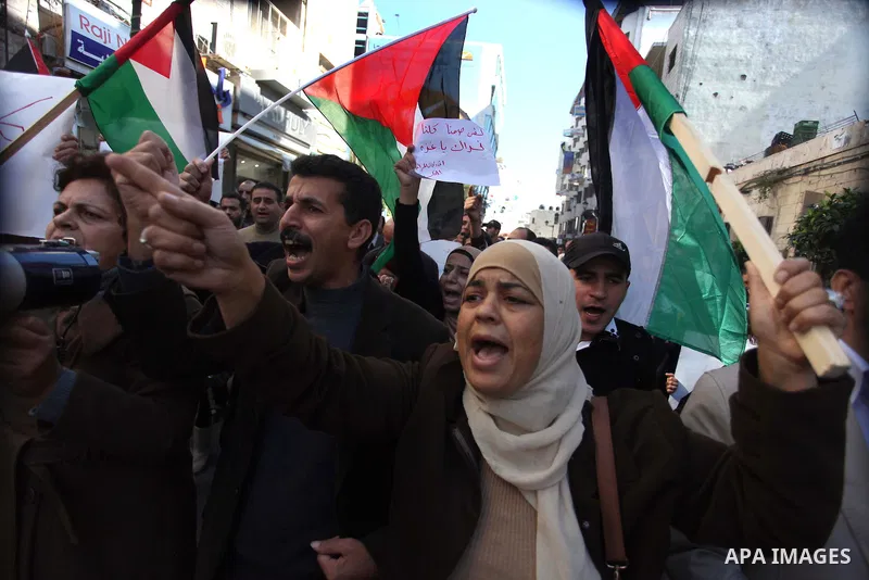 Palestinian activists hold their national flags during a protest against the Israeli military operations in Gaza strip, in the West Bank city of Ramallah on November 15, 2012. Several Palestinians were killed following a...