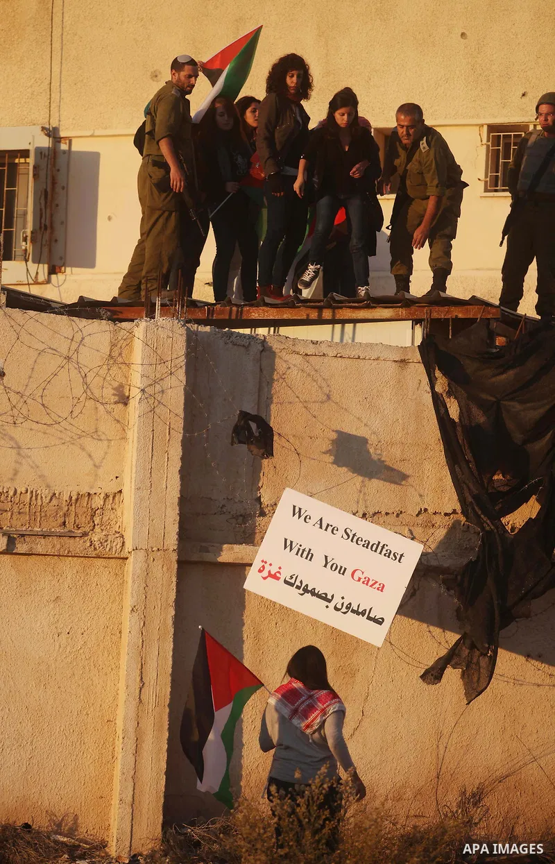 Palestinian feminine activists break inside a military camp near the West Bank city of Ramallah on Nov. 15, 2012. About 20 Palestinian activists Break in Biet Eil militarily camp rising Flags and banners supporting Gaza...