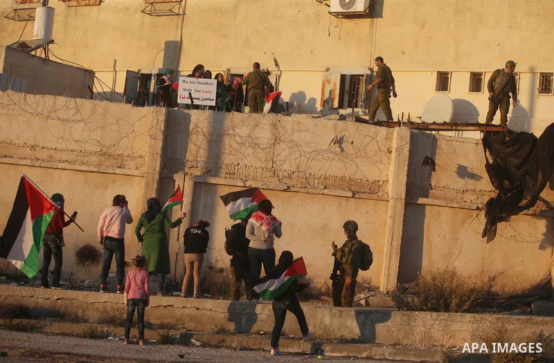 Palestinian feminine activists break inside a military camp near the West Bank city of Ramallah on Nov. 15, 2012. About 20 Palestinian activists Break in Biet Eil militarily camp rising Flags and banners supporting Gaza...